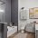 Model bathroom at our apartments in Addison, featuring wood grain floor paneling and a bath and shower.