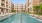 The pool area at our apartments in Addison, featuring beach chairs, fountains, and a view of the apartments.