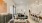 Model living room at our Addison apartments, featuring wood grain floor paneling and counter seating at the kitchen island.