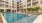 The pool area at our apartments in Addison, featuring beach chairs, fountains, and a view of the apartments.