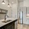 Model kitchen at our apartments in Addison, featuring wood grain floor paneling and stainless steel appliances.