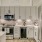 Model kitchen at our apartments in Addison, featuring wood grain floor paneling and stainless steel appliances.